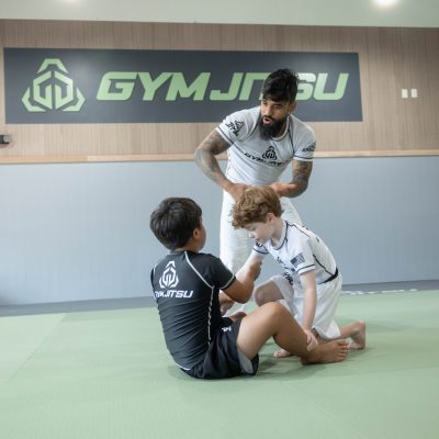 MMA instructor teaching a group of kids striking and grappling fundamentals.