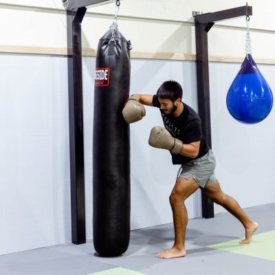 Child practicing boxing combinations on focus pads during youth striking class in Allen, Texas.